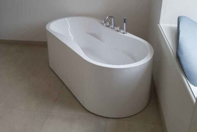 Bad nach Badsanierung mit Bodenfliesen und moderner Badewanne