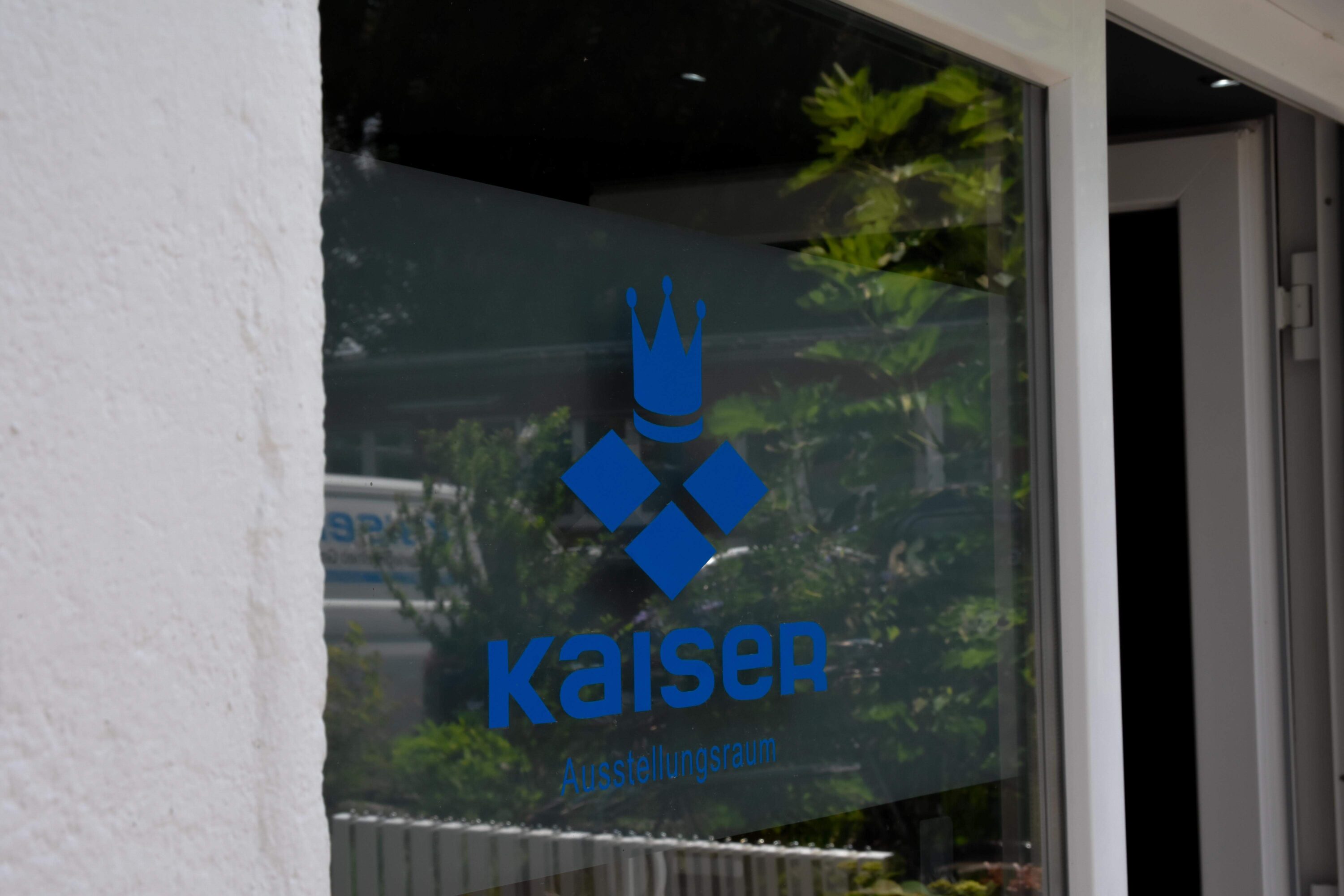 Logo von Kaiser Fliesenverlegebetrieb GmbH aus Düsseldorf Gerresheim an der Scheibe der Fliesenausstellung. Fliesenleger aus Düsseldorf