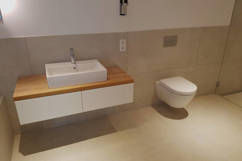 Saniertes Bad mit neuen Badfliesen in beige, verlegt von Kaiser Fliesenverlegebetrieb GmbH aus Düsseldorf