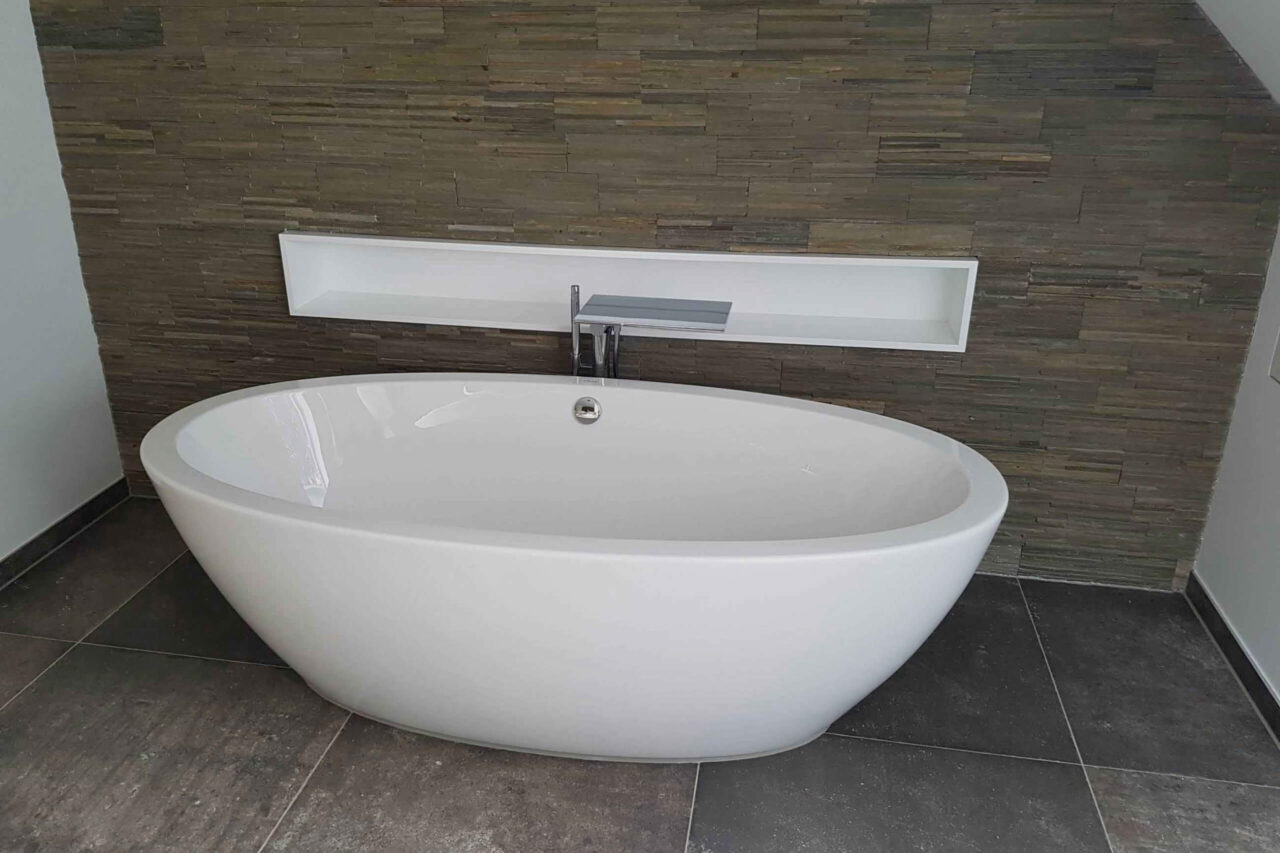 Modernes, saniertes Badezimmer Badewanne und mit Badfliesen geflieste Wand